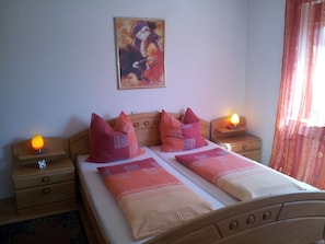 A double bed with two nightstands, each with a lamp, in a room with a painting on the wall. - Apartment 'Ferienwohnung Meier' with Balcony and Wi-Fi (Kressbronn am Bodensee)