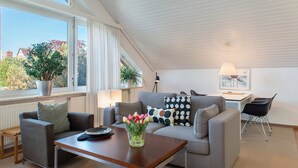 Een moderne woonkamer met een bank, salontafel en uitzicht op de omgeving.