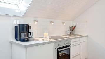 Een koelkast, een oven, een kookplaat, een koffiezetapparaat/waterkoker