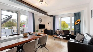 Una sala de estar moderna con comedor, ventanas amplias y vistas al exterior.