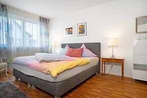 A bedroom with a bed, bedside tables, a chair, and artwork on the wall. - Apartment 'Ins Blaue, 73qm' with Balcony and Wi-Fi (Langenargen)