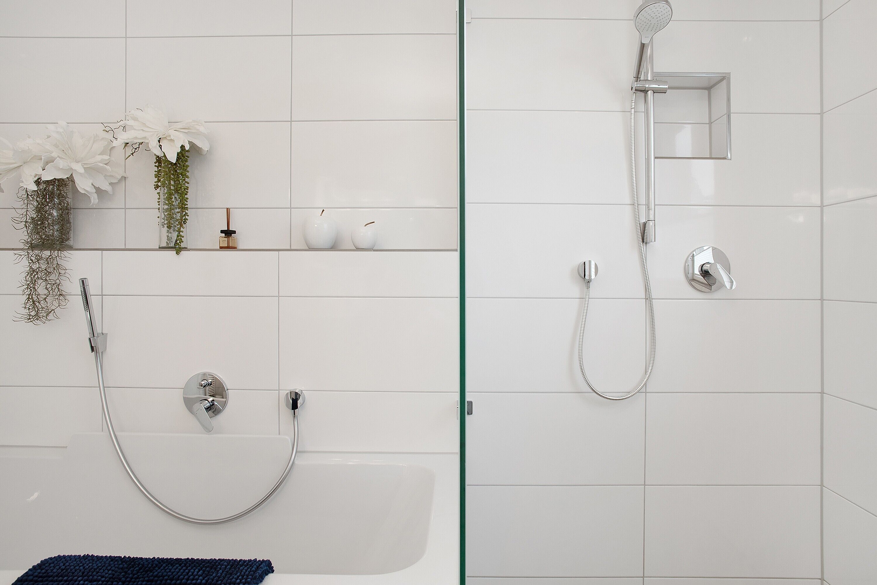 Ein Badezimmer mit Dusche, Badewanne und Glasabtrennung.