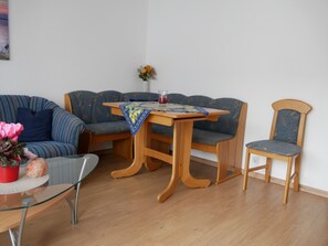 Una sala de estar con un sofá, una mesa de madera y una silla.