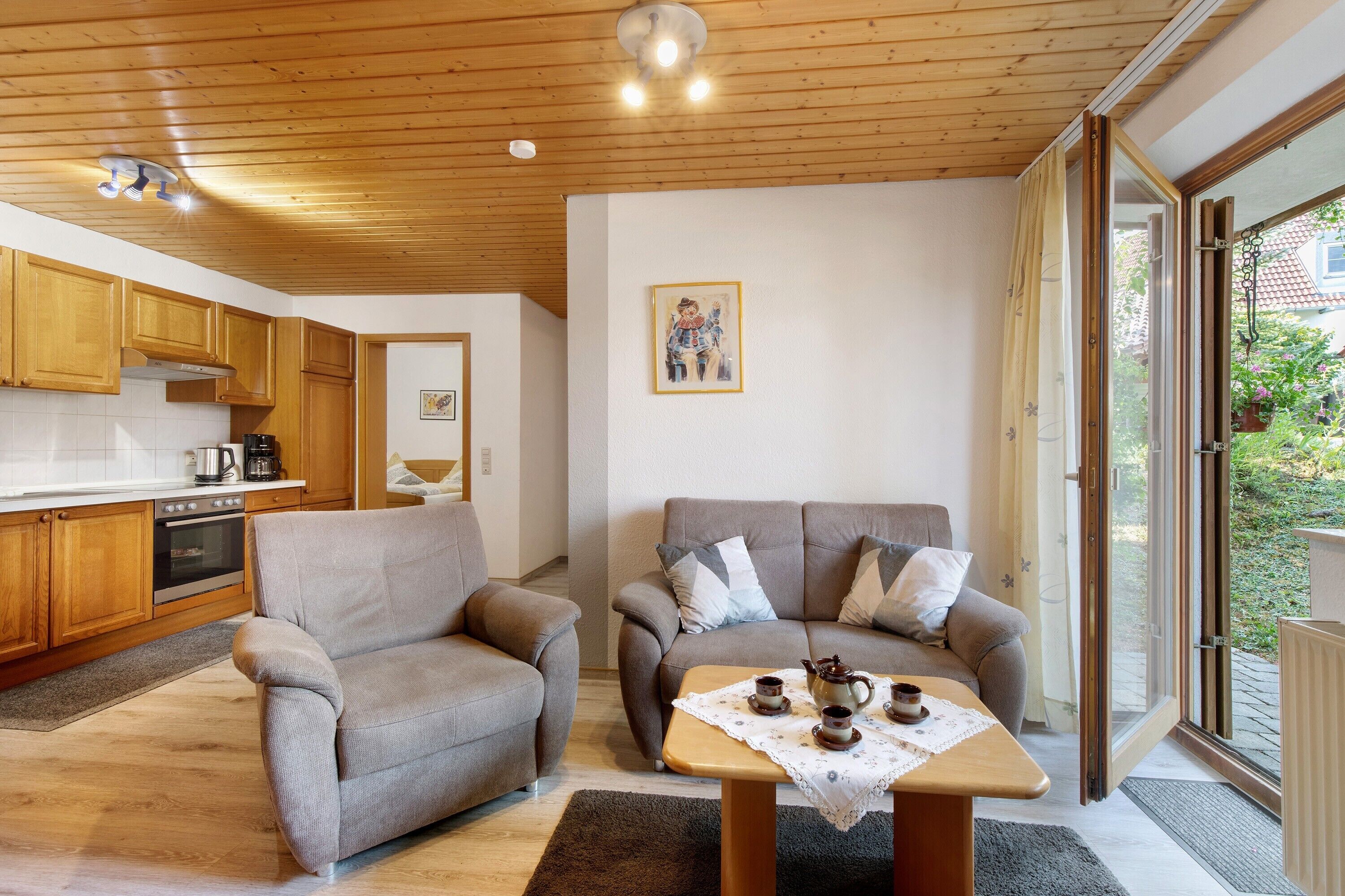 A cozy living area with two sofas, a coffee table, and a kitchen in the background.