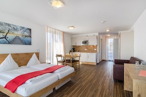 Habitación de hotel con cama, una mesa de comedor, cocina y zona de estar.