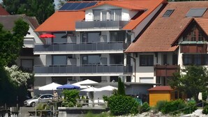 A multi-story building with balconies, a swimming pool, and a waterfront view. - Apartment 'Typ A2' with Shared Terrace, Shared Garden and Wi-Fi (Immenstaad am Bodensee)