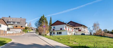 Eine Wohnstraße mit Häusern, blauem Himmel und einem Verbotsschild.