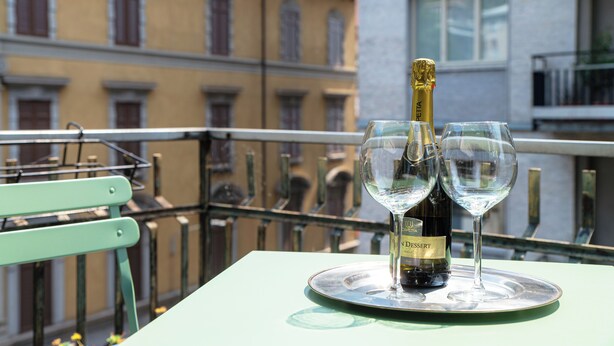 A table with a bottle of champagne and two glasses on a tray. - Suite Duomo View 47 (Como)