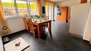 Una cocina moderna con baldosas oscuras, una mesa de comedor de madera y sillas.