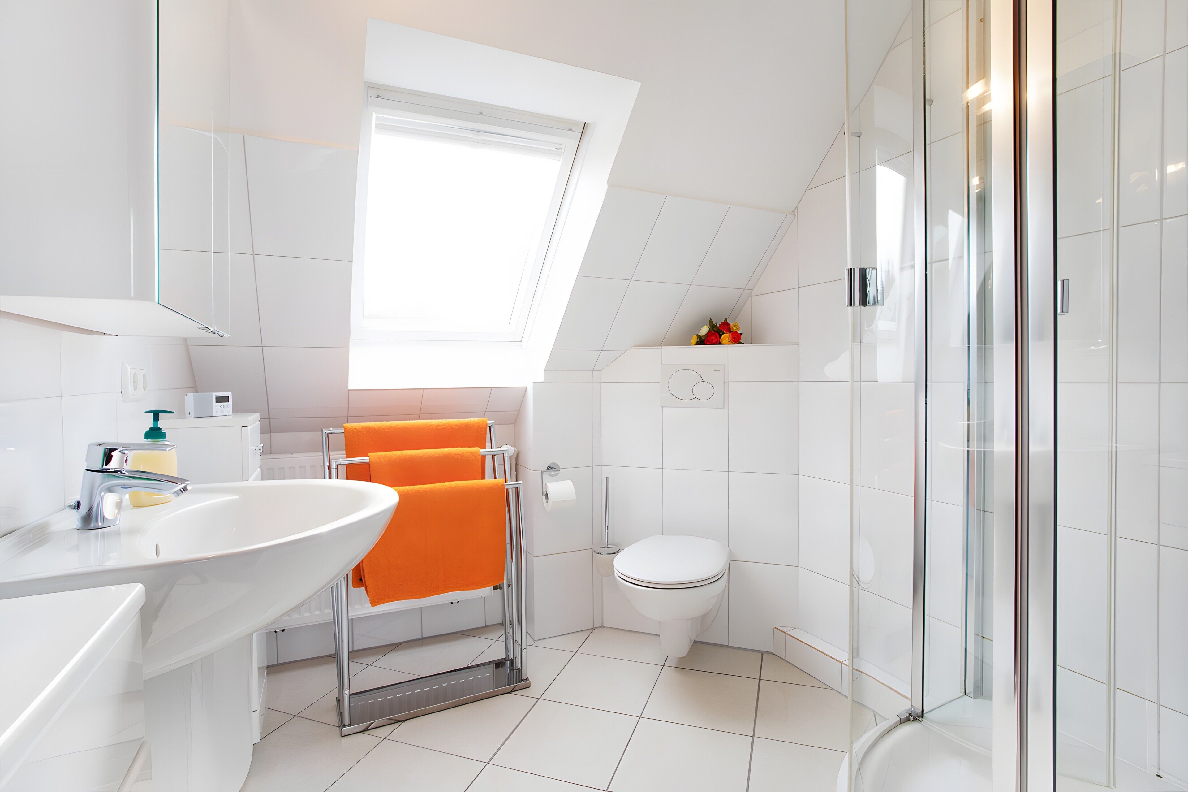 Une salle de bain moderne avec un lavabo blanc, une douche en verre et des toilettes.
