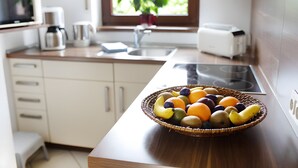 Eine Küche mit Obstschale auf der Arbeitsplatte, einem Toaster und einer Kaffeemaschine.