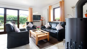 Ein Wohnzimmer mit einer Couch, einem Sessel und einem Couchtisch.