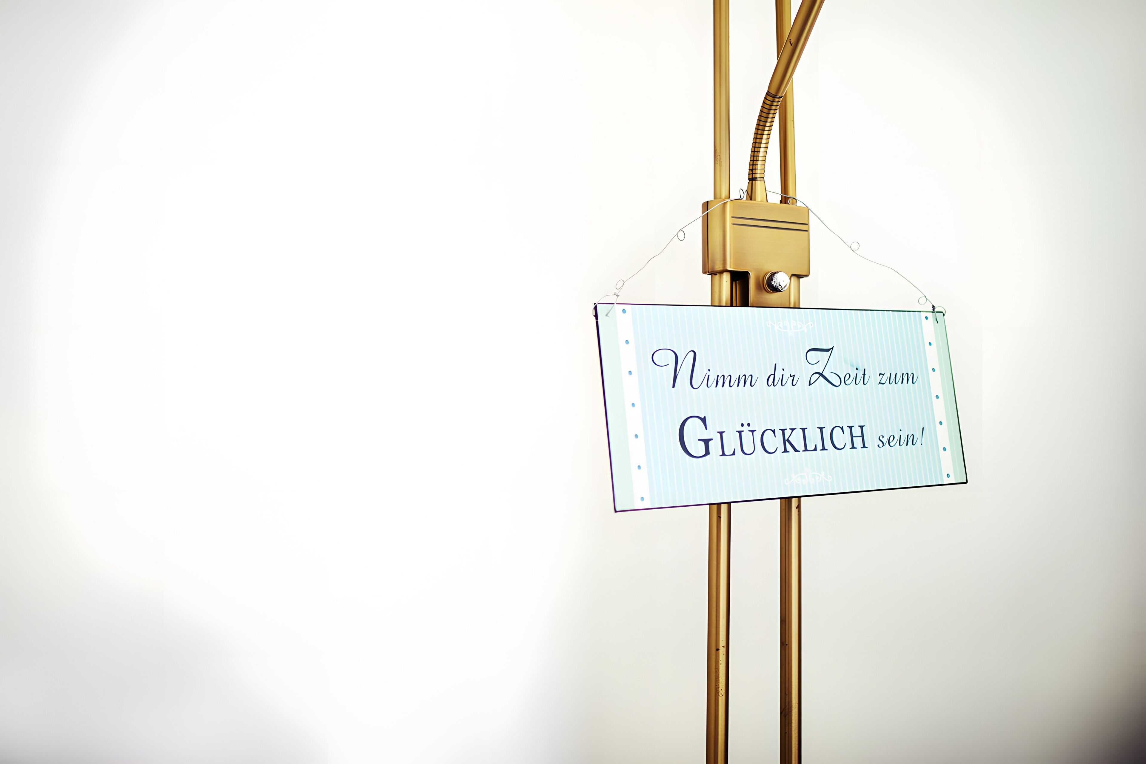 Ein Schild mit deutschem Text, angebracht an einer goldfarbenen Struktur.