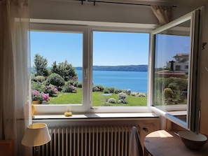 Una habitación con un ventanal que ofrece vistas a un lago y vegetación.