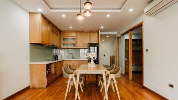 Una cocina moderna con armarios de madera, una mesa de comedor con sillas y un refrigerador.