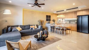 A modern living room with a sofa, coffee table, and dining area.