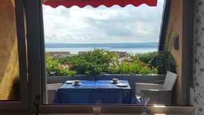 A balcony with a table set for two, overlooking a body of water and a distant landscape. - Apartment 'Koberstaedt' Panoramic Lake View, Balcony and Wi-Fi (Meersburg)