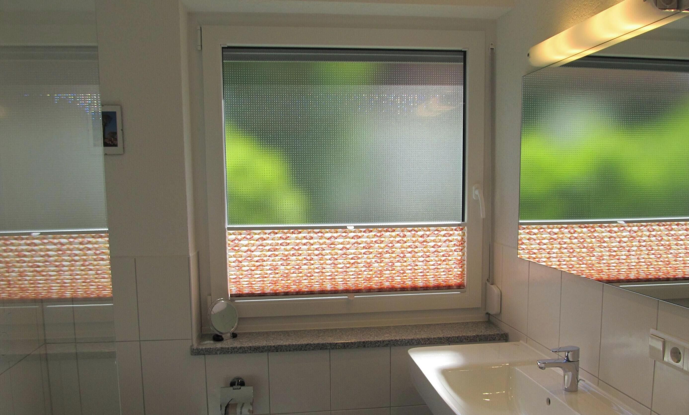Un baño con ventana, lavabo y espejo.