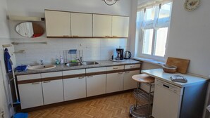 A kitchen with a sink, countertop, cabinets, a coffee maker, and a window. - Holiday Home 'Marienblick' with Private Terrace, Private Garden and Wi-Fi (Beeskow)
