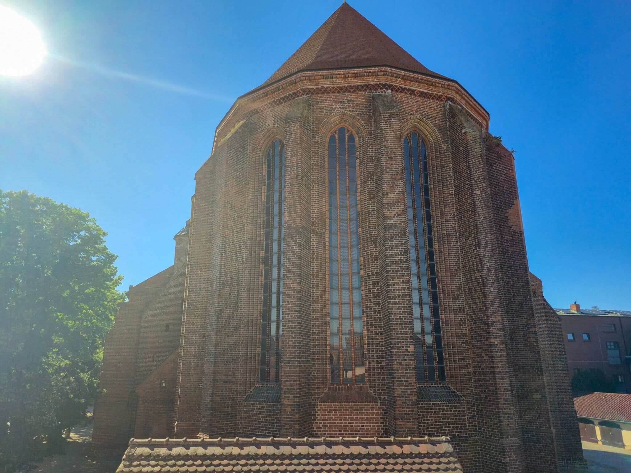 A brick building with a pointed roof and large arched windows.