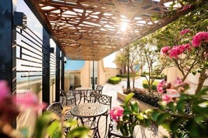 Guests can enjoy socializing at the patio, surrounded by a beautifully maintained garden.