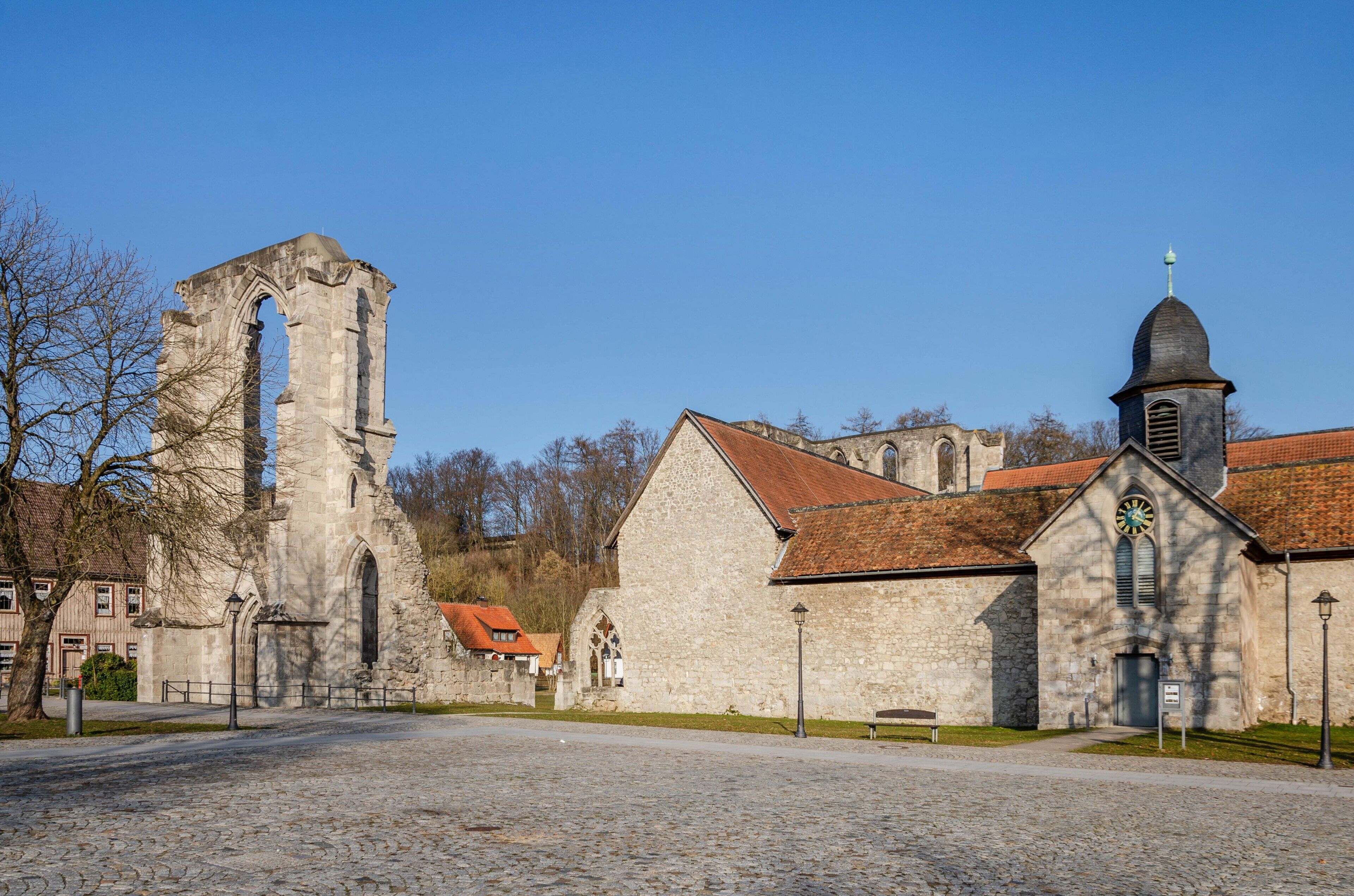 Eine historische Steinkirche mit einem Glockenturm und einer großen, gewölbten Ruine.