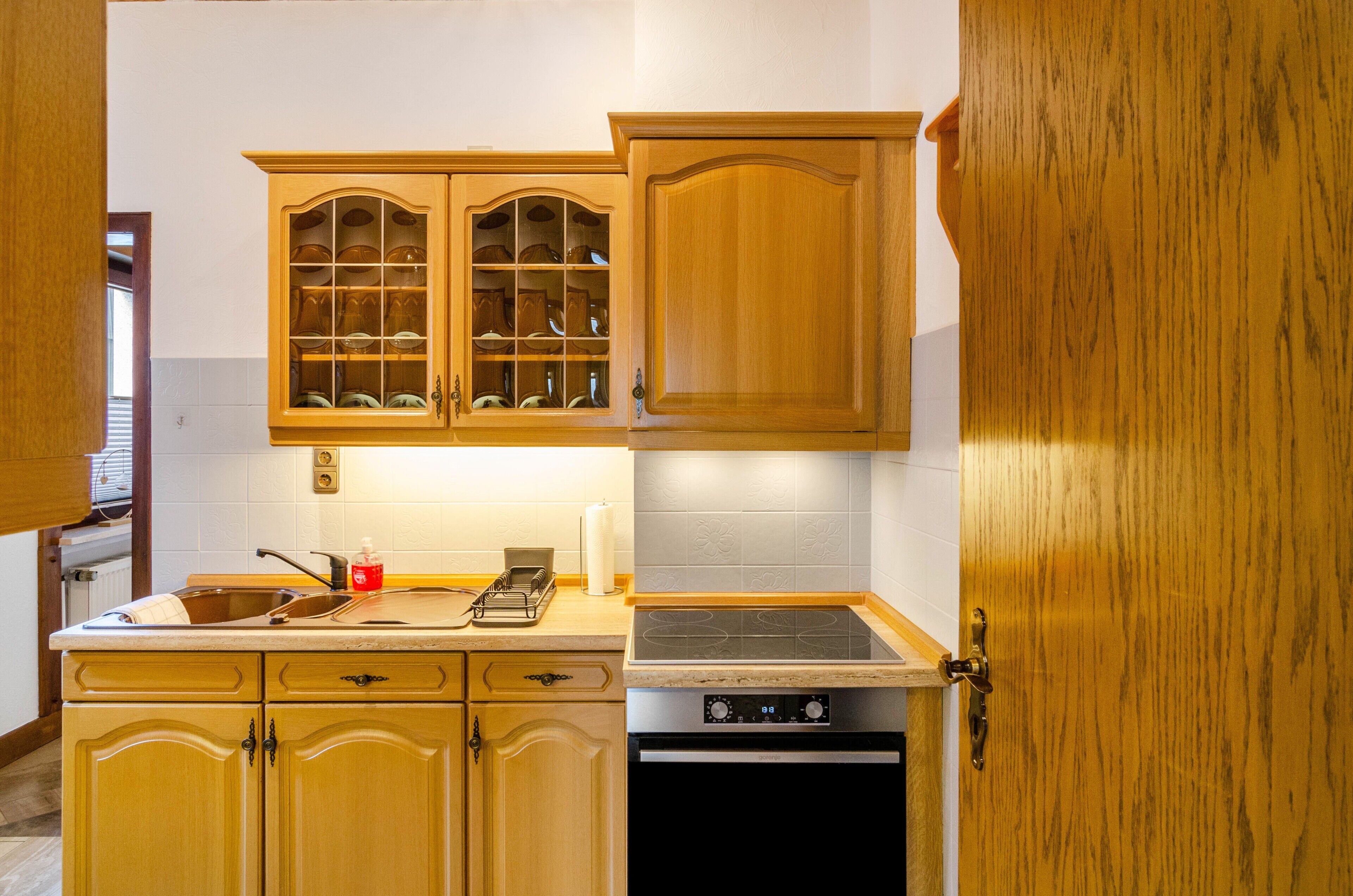 A kitchen with wooden cabinets, a stove, and a dishwasher.