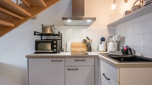 Eine moderne Küche mit Mikrowelle, Toaster, Kaffeemaschine und Schneidebrett aus Holz.