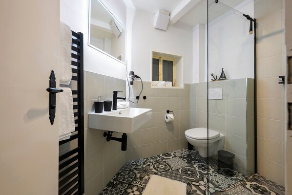 A bathroom with a sink, toilet, and shower.