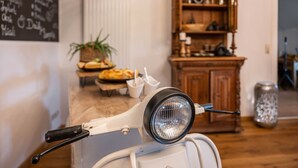 A kitchen with a white appliance, wooden cabinets, a chalkboard menu, and a plant. - Knutzenswarft - Holiday Apartment "Möwe" (Westerhever)