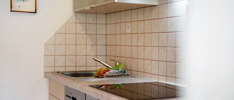 A kitchen with a sink, a dish rack, and a dishwasher.