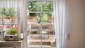 A room with a window, a radiator, a clock, and a plant. - Holiday Apartment 'Vergissmeinnicht' with Mountain View, Shared Garden and Wi-Fi (Kirchzarten)