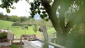 A rustic outdoor setting with a water feature, wooden furniture, and a bicycle. - Sunny Apartment, 85 sqm, 2 Bedrooms, Max. 6 Guests (Kirchzarten)