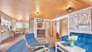 A spacious living area with a blue sofa, a white coffee table, and a wooden ceiling. - Sunny Apartment, 85 sqm, 2 Bedrooms, Max. 6 Guests (Kirchzarten)