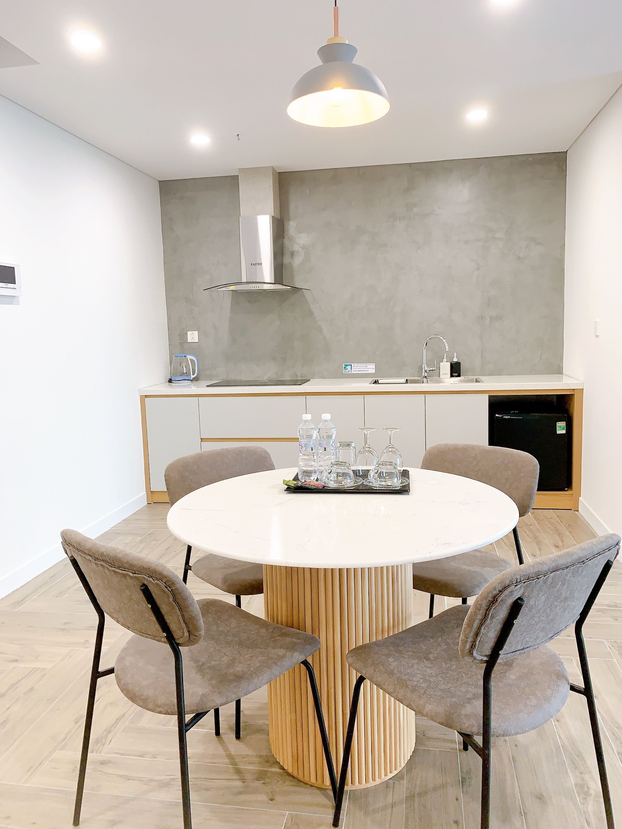 A modern kitchen with a round dining table, chairs, and a built-in oven.