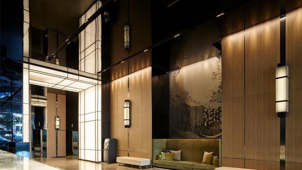 A modern lobby with a seating area, a reception desk, and a large wall mural. - Ha Tay Millennium Apartments - Free Gym Pool (Hanoi)