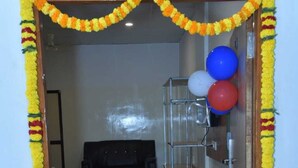 Un ingresso adornato da ghirlande di calendula, che dà su una stanza con un divano e una mensola in metallo.