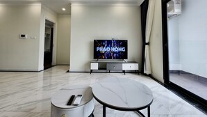 Een moderne woonkamer met een flatscreen televisie, een marmeren salontafel en een minimalistisch design.