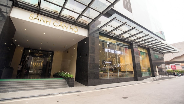 Un bâtiment moderne avec une façade en verre et une enseigne indiquant « SÀNH CÁNH HỒ ».