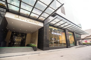 A modern building with a glass facade and a sign reading "SÀNH CÁNH HỒ".