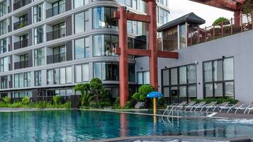 Un hôtel moderne doté d’une piscine sur le toit, d’un jacuzzi et d’un espace salon couvert.