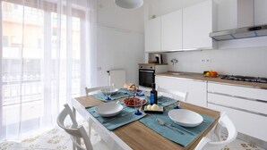 Une cuisine moderne avec des armoires blanches, un four encastré et une cuisinière à gaz.