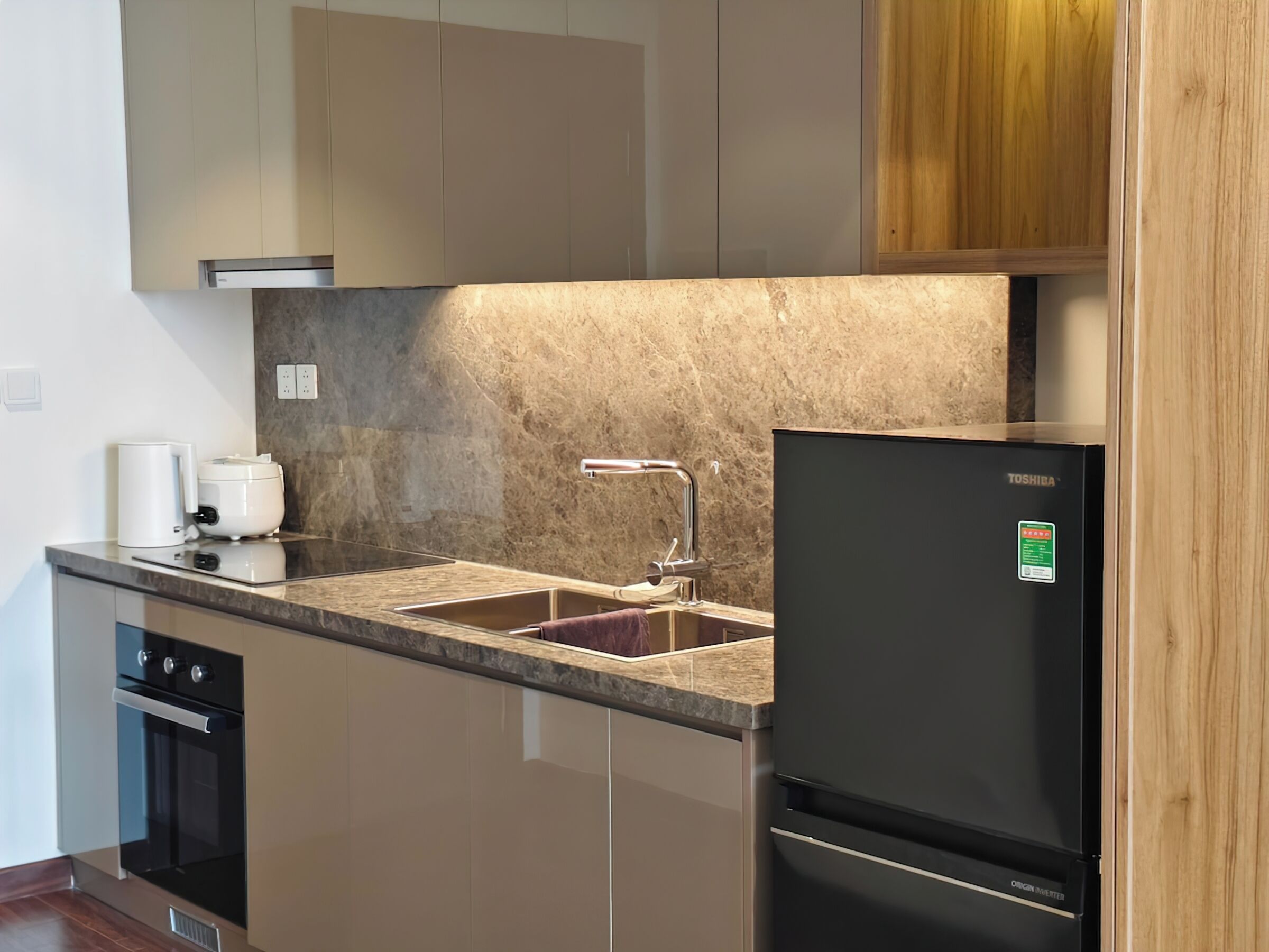 Una cocina moderna con horno empotrado, refrigerador y pileta.