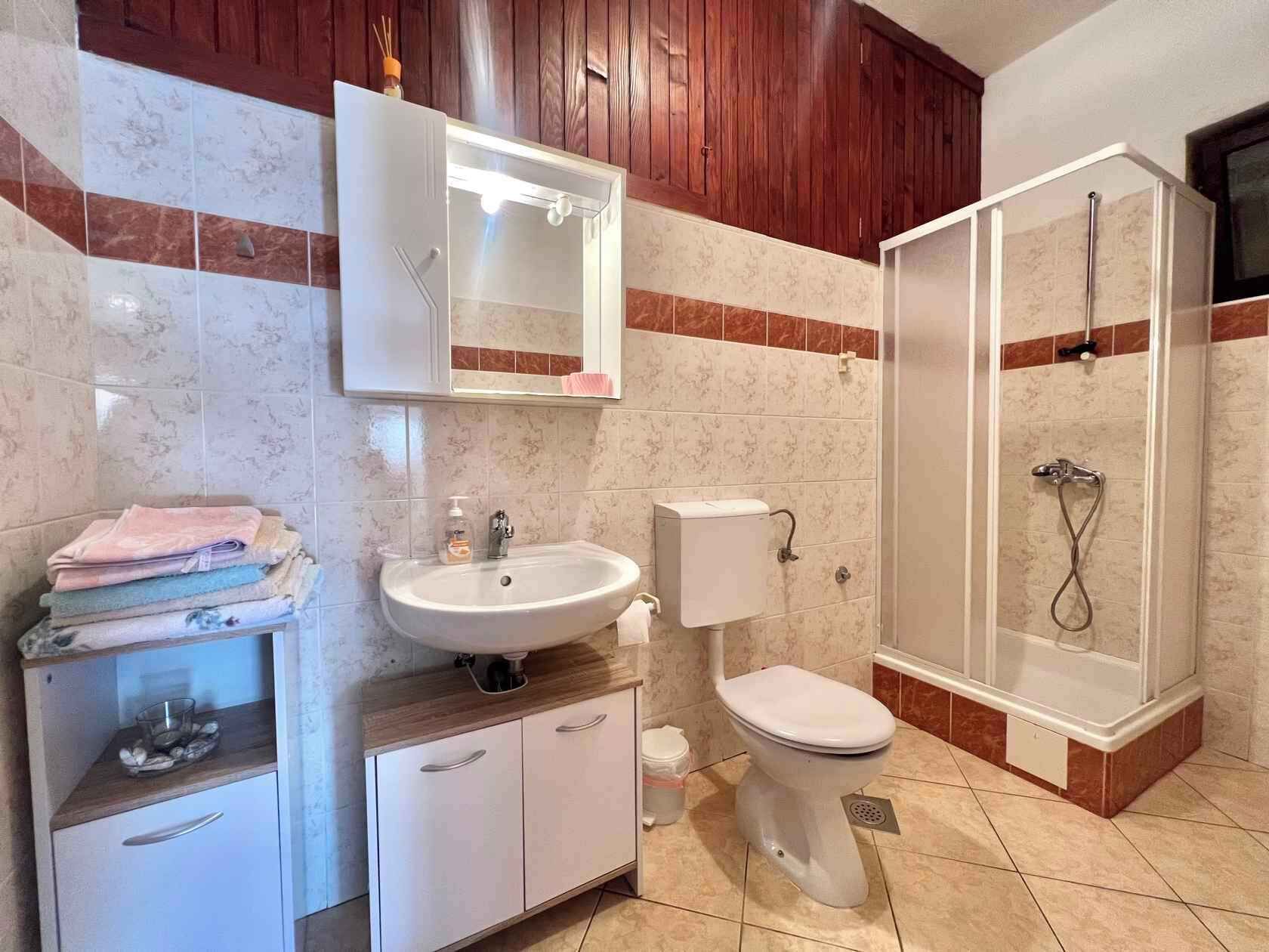 A bathroom with a sink, toilet, and shower.