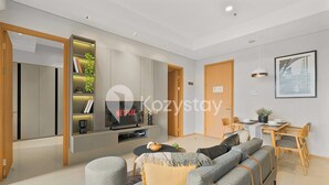 A modern living room with a sofa set, a TV, and a bookshelf.