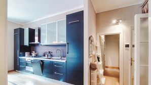 Una cocina moderna con armarios oscuros, horno empotrado y pileta.