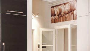 Una habitación con un armario oscuro, una puerta blanca y un aplique de pared.