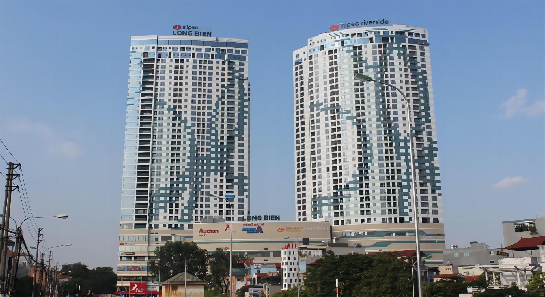 Dos edificios altos con señalización que indica 'Mipec Long Bien' y 'Mipec Riverside'.