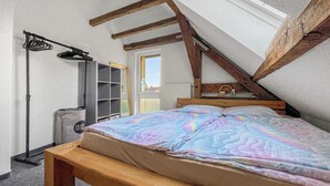 A bedroom with a wooden bed, a window, and a radiator. - Cozy & nature-loving apartment “Lichtblick” (Tschernitz)
