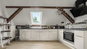 A kitchen with white cabinets, a built-in oven, and a window. - Cozy & nature-loving apartment “Lichtblick” (Tschernitz)